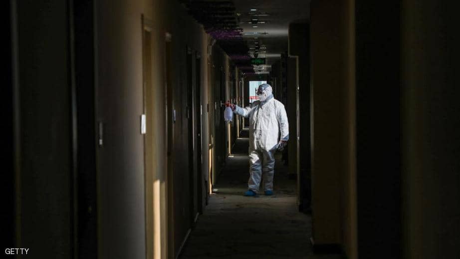 A sanitation worker sanitizes a quarantine area in the affected city